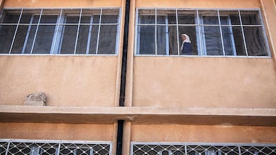 A Syrian girl looks out of a window of the public school in Madaya village, Syria. AP Photo