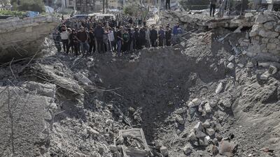 Palestinians gather at the site of an Israeli air attack on a camp housing displaced civilians in Gaza city. Bloomberg