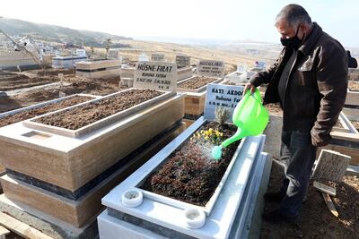 A man waters flowers on a grave in Ortakoy cemetery, the main burial site for people who died of Covid-19, in Mamak, district of Ankara, December 10. AFP