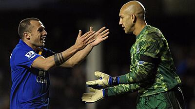 John Heitinga (L) congratulates Everton's American goalkeeper Tim Howard, right, after the keeper scored from his own goal area.
