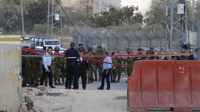 Israeli soldiers gather in the settlement of Kiryat Arba in the West Bank town of Hebron after a Palestinian was shot dead at a similar checkpoint earlier. AFP