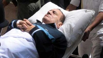Mubarak on a stretcher while being taken to the courtroom during his trial. Sources now say the former leader is in a coma.