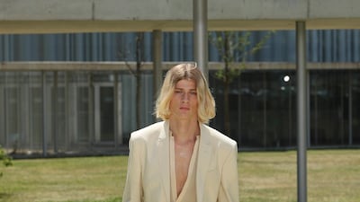 A fluid suit in neutral tones.