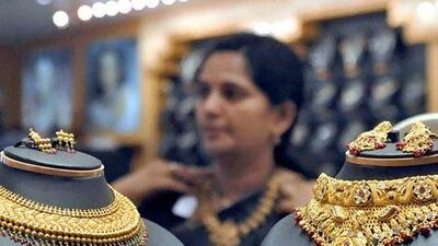 A woman tries on a gold necklace in a Hyderabad jewellery shop. Holding assets in gold is a useful hedge against extreme events. Krishnendu Halder / Reuters