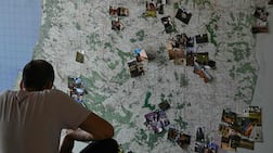 Photographs pinned to a map of southern Lebanon at Hkeeli Ya Jnoub, where family images and personal archives are helping preserve memories of villages affected or destroyed by conflict. AFP