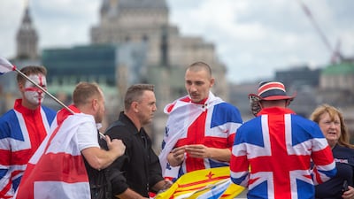 Protesters wrap up in St George's and Union flags at the Unite The Kingdom rally in central London. A counter demonstration was organised by anti-racism campaigners under the banner of Stand Up to Racism. EPA
