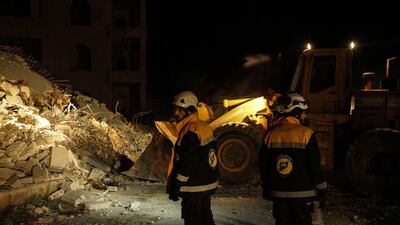 Syrian civil defense volunteers walk next to a bulldozer near civilian buildings which were destroyed in airstrikes in Idlib city. EPA/YAHYA NEMAH