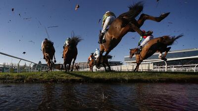 Runners clear the water jump in the Steeple Chase at Newbury Racecourse in England. Alan Crowhurst / Getty Images