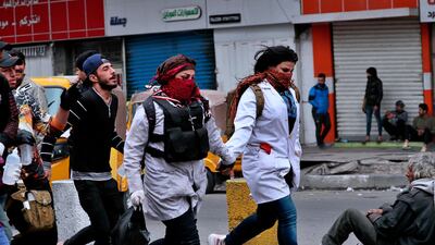 Protesters run to take cover during clashes with security forces in central Baghdad. AP Photo