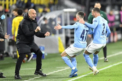 Manchester City manager Pep Guardiola celebrates with goalscorer Phil Foden and Kyle Walker (right) against Dortmund in April.