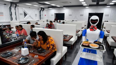 Customers at a cafe in India are served by a robot. AI is increasingly being used across industries in India and is poised to transform the economy. AFP