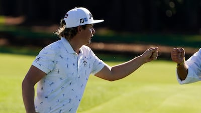 Cameron Smith, of Australia, fist pumps a caddie on the 18th hole. PA