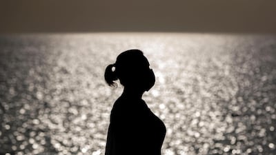 A woman wears a protective mask on Nikki beach resort and spa in Dubai. Chris Whiteoak / The National