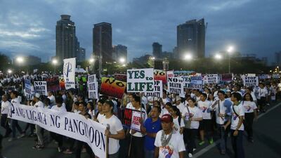 Thousands of Roman Catholics march around Manila's Rizal Park to oppose the revival of the death penalty by the Philippine Congress as well as the killings of drug users and drug pushers in the so-called war on drugs by President Rodrigo Duterte. (AP Photo/Bullit Marquez)