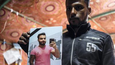A young protester holds up a picture of a fellow demonstrator killed on the morning of January 22, 2020. Luke Pierce for The National
