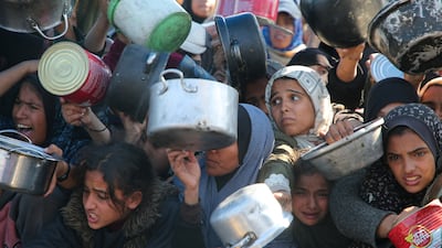 Displaced Palestinians receive food at a charity kitchen in Khan Younis, January 2025. Reuters