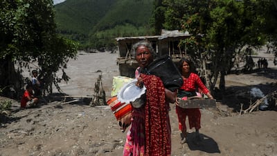 Women carry belongings from their damaged homes after a flash flood and a mudslide, in Galchhi, Nepal. Reuters