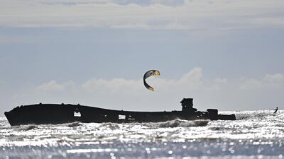 A kite surfers pass a ship wreck on Camber Sands beach, south-east England on Sunday, August 23. AFP