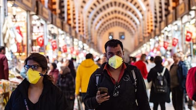 A man and woman wearing facemasks walk in a historic bazaar in the central Sultanahmet district of Istanbul. AFP