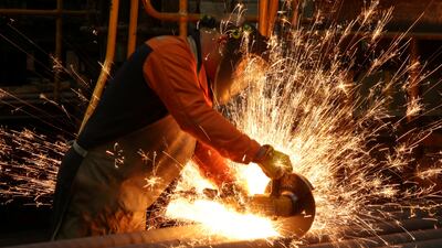 A worker cuts newly manufactured bars of steel at the United Cast Bar Group's foundry in Chesterfield, Britain. Reuters