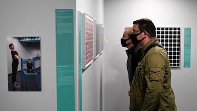Two visitors wearing protective masks visit the Museum of Illusion in Paris. AFP