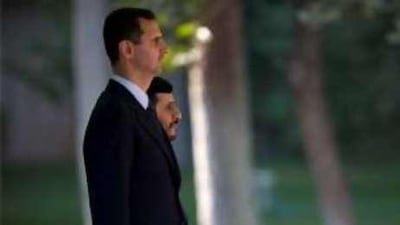 The Syrian president Bashar Assad, left, and his Iranian counterpart Mahmoud Ahmadinejad listen to the Syrian national anthem in Tehran.