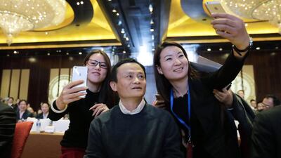 Female delegates take "selfies" with Alibaba Group executive chairman Jack Ma as he arrives for the Fifth Conference of Zhejiang Chamber of Commerce in Beijing, December 6, 2014. Ma was awarded Honorary Chairman of Zhejiang Chamber of Commerce during the conference. Jason Lee / Reuters