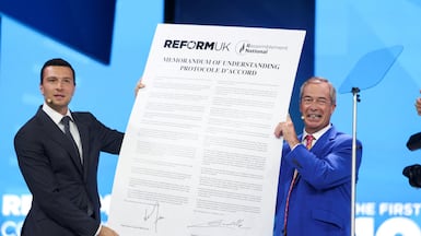 Nigel Farage, and Jordan Bardella hold aloft their agreement on returning Channel migrants to French shores. Reuters