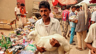 A Yemeni man carries a lamb at a market in Yemen's northwestern Hajjah province. AFP