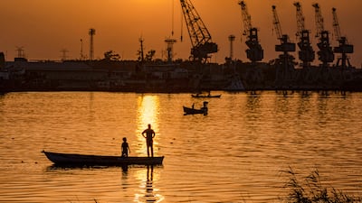 A fisherman stands in a boat in the Shatt Al Arab river by the port of Al Maqal in the southern Iraqi city of Basra.
