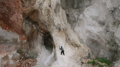 A worker pounds a wall of rock to make gravel and sand in the Kenscoff neighbourhood of Port-au-Prince, Haiti. AP