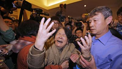 A family member of a passenger aboard Malaysia Airlines MH370 cries as she is surrounded by journalists after watching a television broadcast of a news conference at the Lido hotel in Beijing on March 24. Jason Lee / Reuters