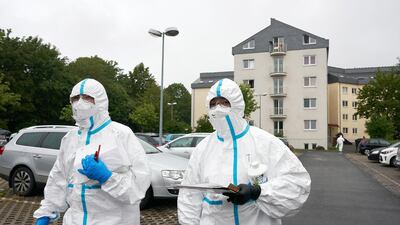 Emergency personnel in protective clothing stand in front of a student dormitory in Koblenz, Germany last week. At one point during the Covid-19 crisis, there was a shortage of PPE in Germany. AP Photo