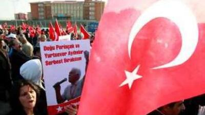 Supporters brandish Turkey flags outside the court where 86 alleged plotters are on trial.