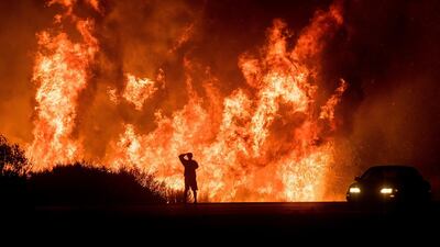 A motorists on Highway 101 watches flames from the Thomas fire leap above the roadway north of Ventura, California, on December 6, 2017. Noah Berger / AP Photo