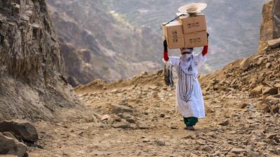 A Yemeni woman carries boxes of food on her head as she walks through the mountains along the only path accessible between the southern cities of Aden and Taez, since the main roads leading to the embattled city of Taez are blocked due to the ongoing fighting between forces loyal to Yemen’s Saudi-backed President Abdrabu Mansur Hadii and Houthi rebels. Ahmad Al-Basha / AFP