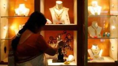 Golden touch: A saleswoman arranges gold jewellery at a jewellery showroom in the Indian city of Siliguri. Indian jewellers have sold more than 50 tonnes of gold in the last 20 days,