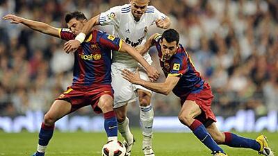 Barcelona forward David Villa, left, and teammate Sergio Busquets attempt to block the run of Real Madrid's Pepe on Saturday.