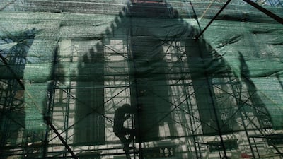 A construction worker walks on scaffolding to renovate Wat Mai Phi Ren temple in Bangkok, Thailand, on Tuesday, February 24, 2015. Sakchai Lalit / AP Photo