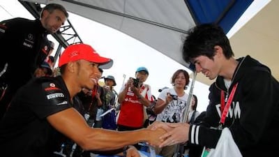 Lewis Hamilton, the McLaren-Mercedes driver, greets a fan at the Suzuka Circuit yesterday ahead of the Japanese Grand Prix.