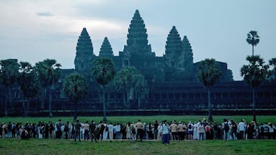 Tourists gather in front of a pond as they wait to take pictures at sunrise at the Angkor Wat temple complex in Siem Reap province. AFP