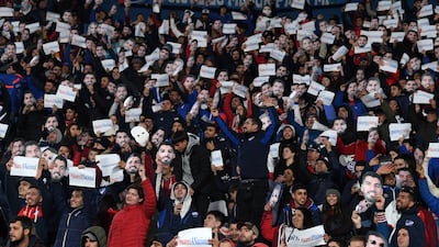 Fans of Nacional wearing Luis Suarez masks and carrying posters of the player at Estadio Gran Parque Central. EPA