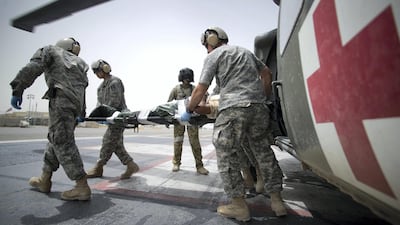 Medics escort an injured person from a helicopter in Kandahar. The Abu Dhabi hospital would be the main treatment and rehab centre for the Middle East. AFP