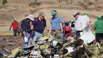 Investigators with the US National Transportation and Safety Board (NTSB) look over debris at the crash site. Getty Images
