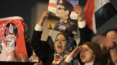 Supporters of Egypt's army chief and defence minister Gen Abdel Fattah El Sisi hold up posters of him as they celebrate the passing of a new constitution at Tahrir Square in Cairo on Saturday. Mohamed Abd El Ghany / Reuters