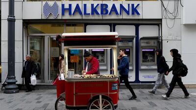 A street vendor sells roasted chestnuts in front of a branch of Halkbank in central Istanbul, Turkey. Reuters