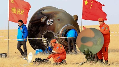 In this photo released by Xinhua News Agency, ground crew check on the re-entry capsule of Shenzhou 11 spacecraft after it landed in north China's Inner Mongolia Autonomous Region, Friday, Nov. 18, 2016. A pair of Chinese astronauts returned Friday from a monthlong stay aboard the country's space station, China's sixth and longest crewed mission and a sign of the growing ambitions of its rapidly advancing space program. (Li Gang/Xinhua via AP)