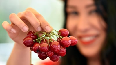 A woman poses with cherries during Cherry Day in the village of Hammana, southeast of Beirut, Lebanon. EPA