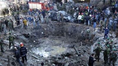 Rescue workers and soldiers stand around a crater from the bomb that tore through the motorcade of Rafiq Hariri in Beirut in 2005.