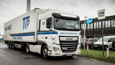 A truck driver holds up an urgent medicines sign as he pulls his truck out of Pfizer Manufacturing in Puurs, Belgium. The European Medicines Agency approved a coronavirus vaccine on Monday. AP
